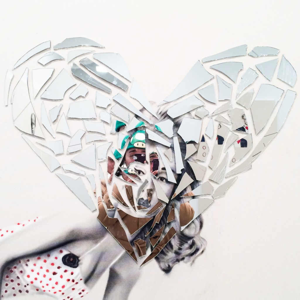 A photo of Kelci Reedy's reflection in a broken, heart-shaped mirror at an art gallery in New York City's Chelsea neighborhood.