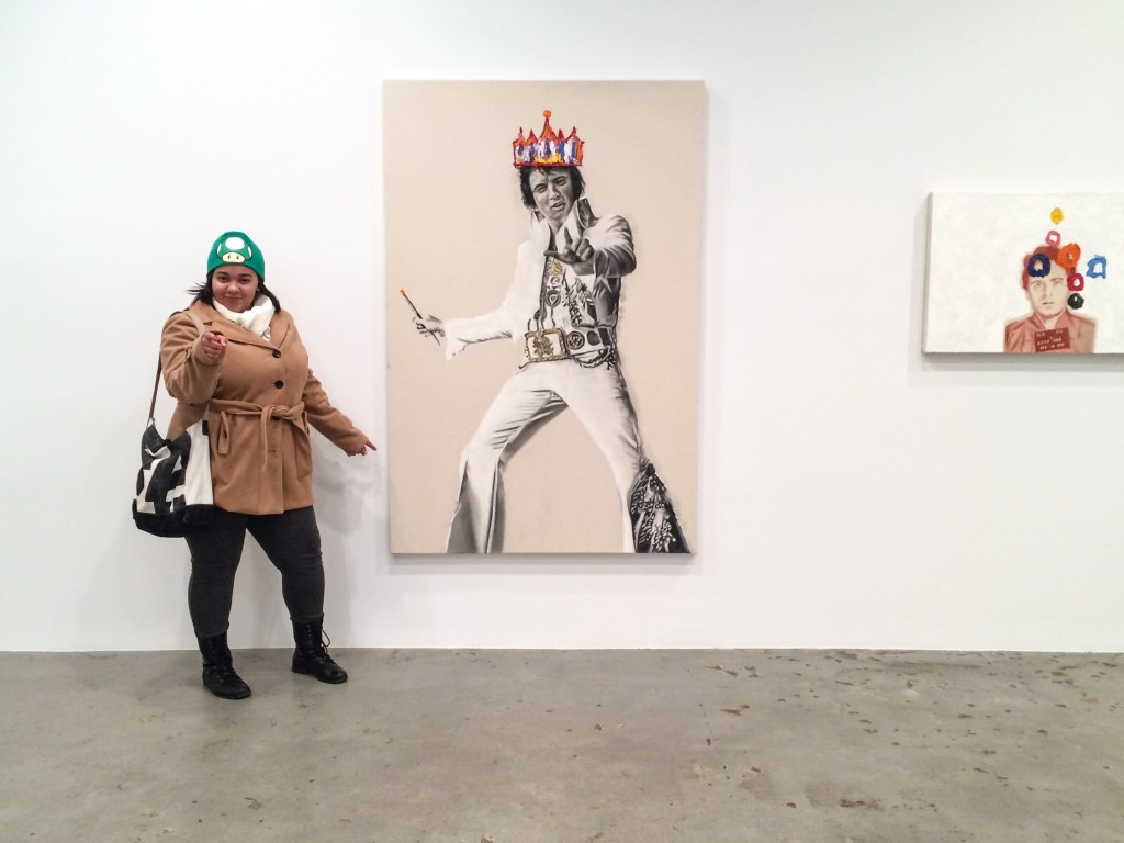 A photo of Kelci Reedy posing with a picture of Elvis at an art gallery in New York City's Chelsea neighborhood.