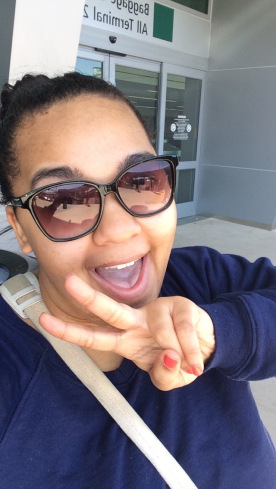 A woman smiling w/peace sign at San Diego International Airport