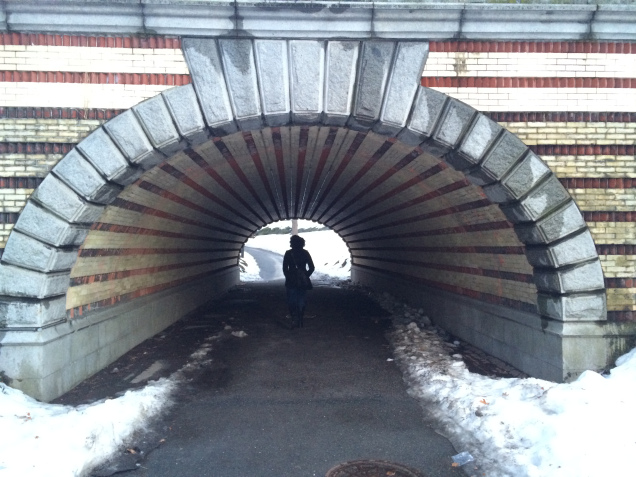 A woman walking through a tunnel in Central Park