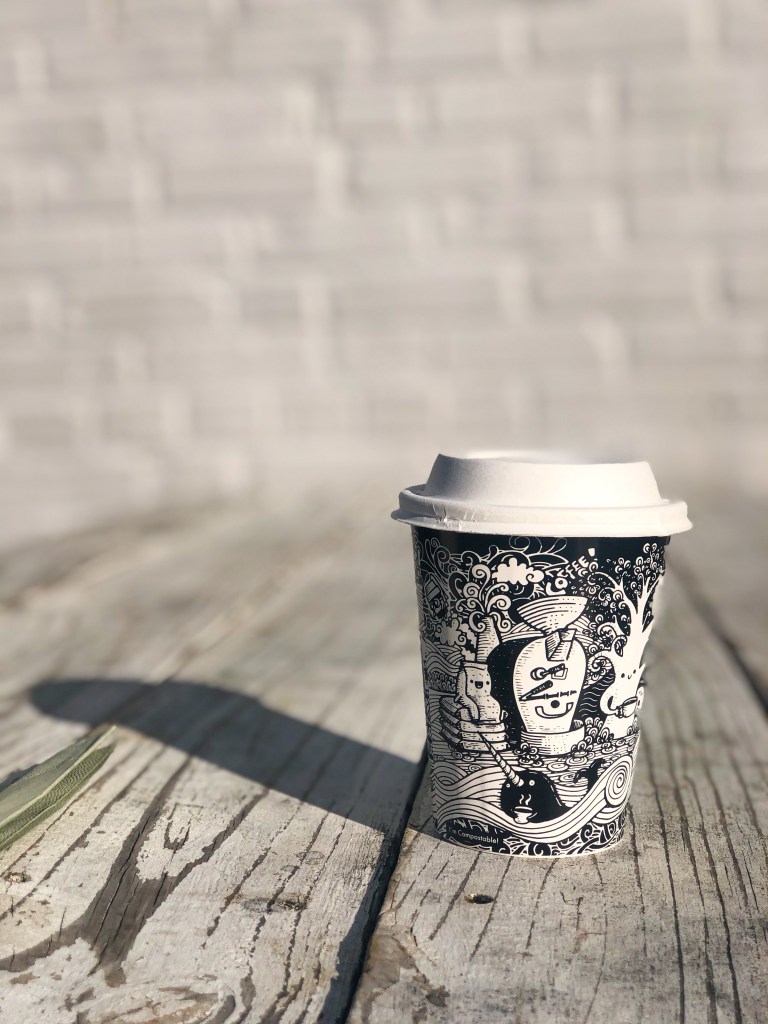 Vanilla latte from Vigilante Coffee​ on top of a picnic table. Vigilante Coffee is a coffee shop based in Maryland.