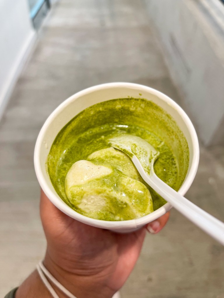 A hand holding a dessert called matcha affogato from La Gelatteria, a cafe in Maryland