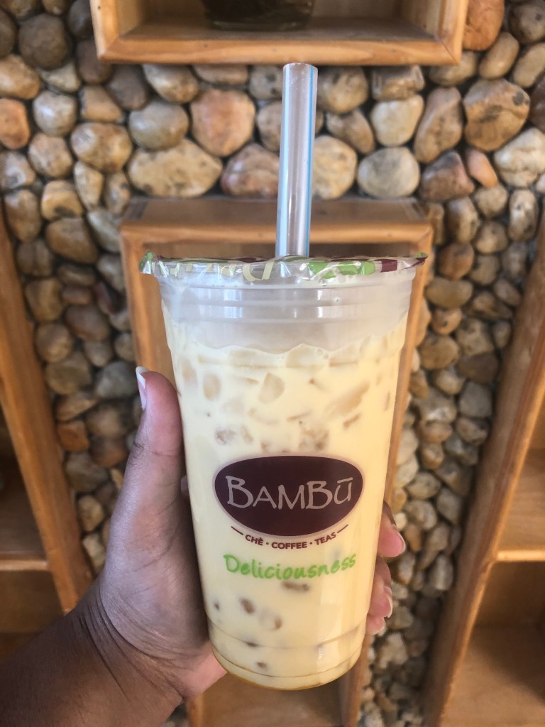 A hand holding Passion Fruit Milk Tea from Bambu, which is a bubble tea shop in Annandale, Virginia.