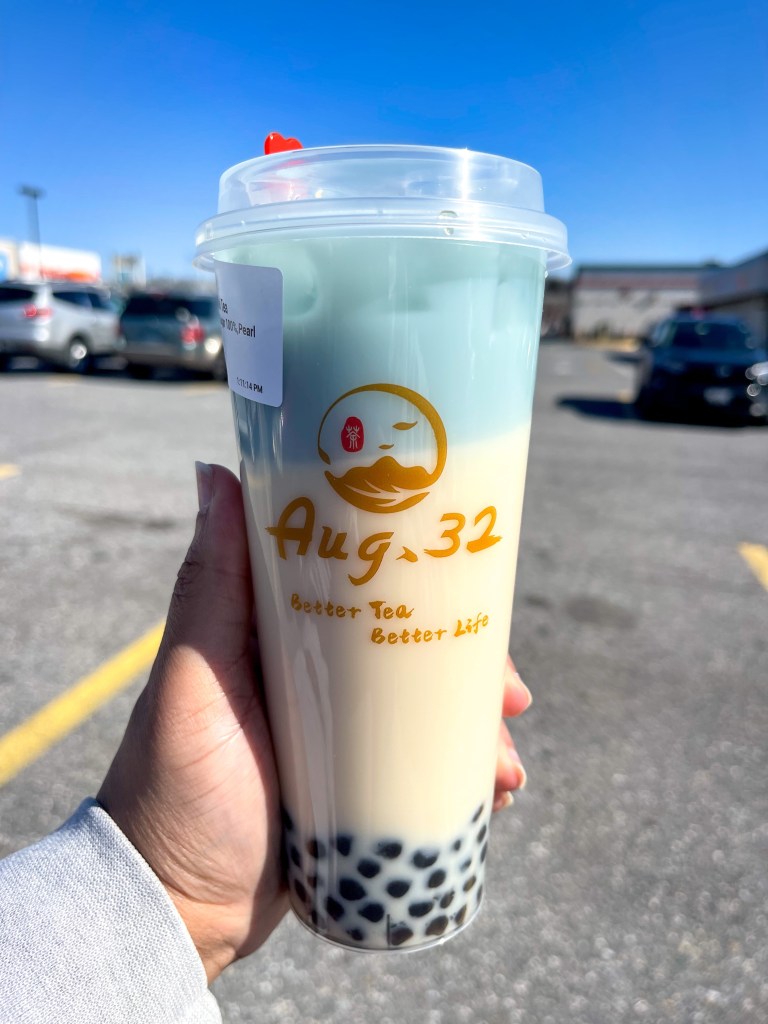 A hand holding a boba tea drink called "Night Sky Milk Tea." It's from August 32, which is a boba tea shop located in Greenbelt, Maryland.