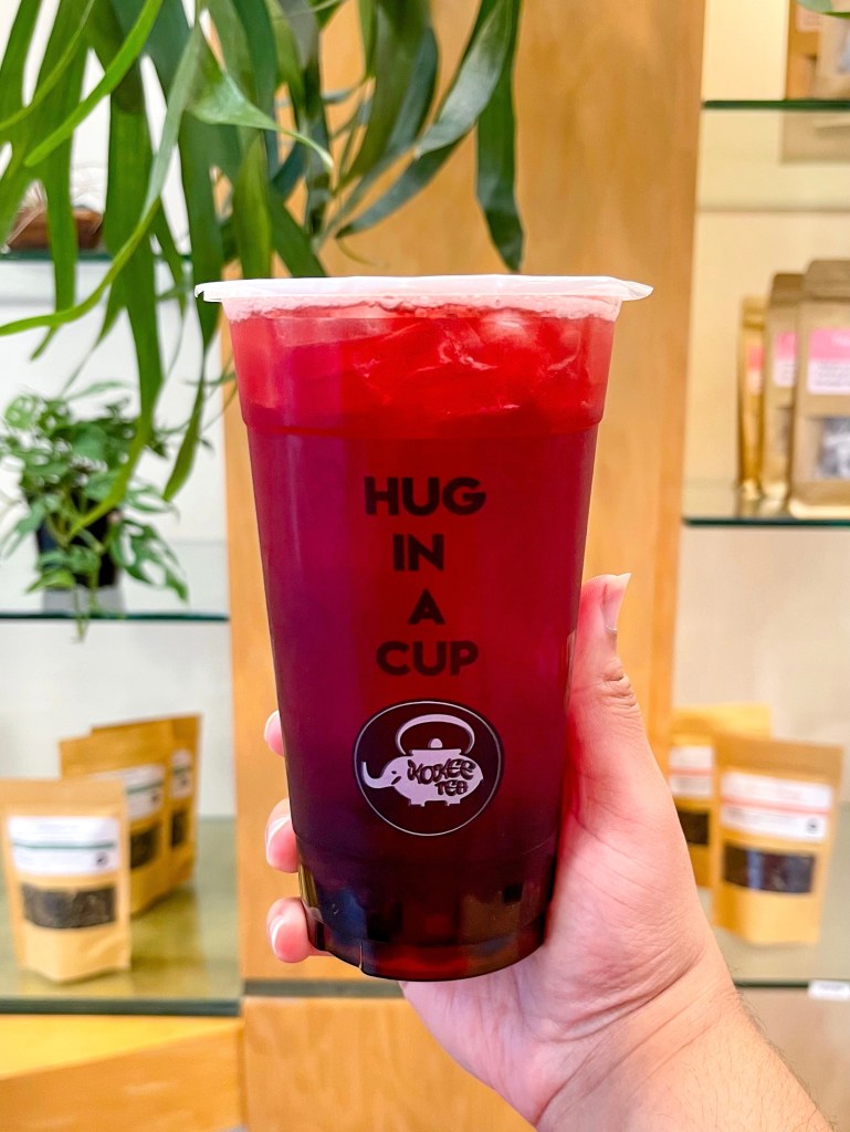A hand holding a boba tea drink called "Dragon & Rose." The drink is from Kokee Tea, which is a boba tea shop franchise in the United States.