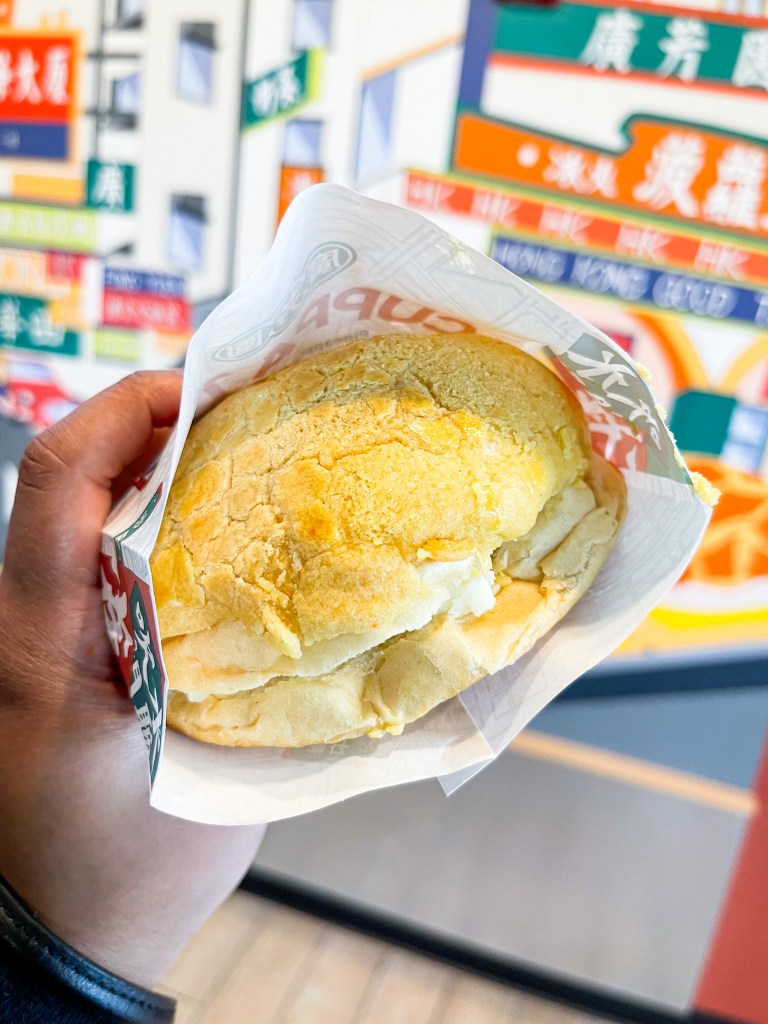A hand holding a buttered pineapple bun from Cuppa Tea, a shop in College Park, Maryland