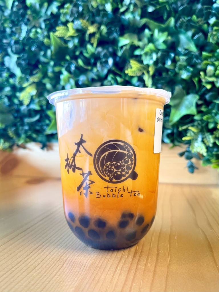 A Thai Milk Tea drink with boba pearls from Tai Chi Bubble Tea sitting on a countertop