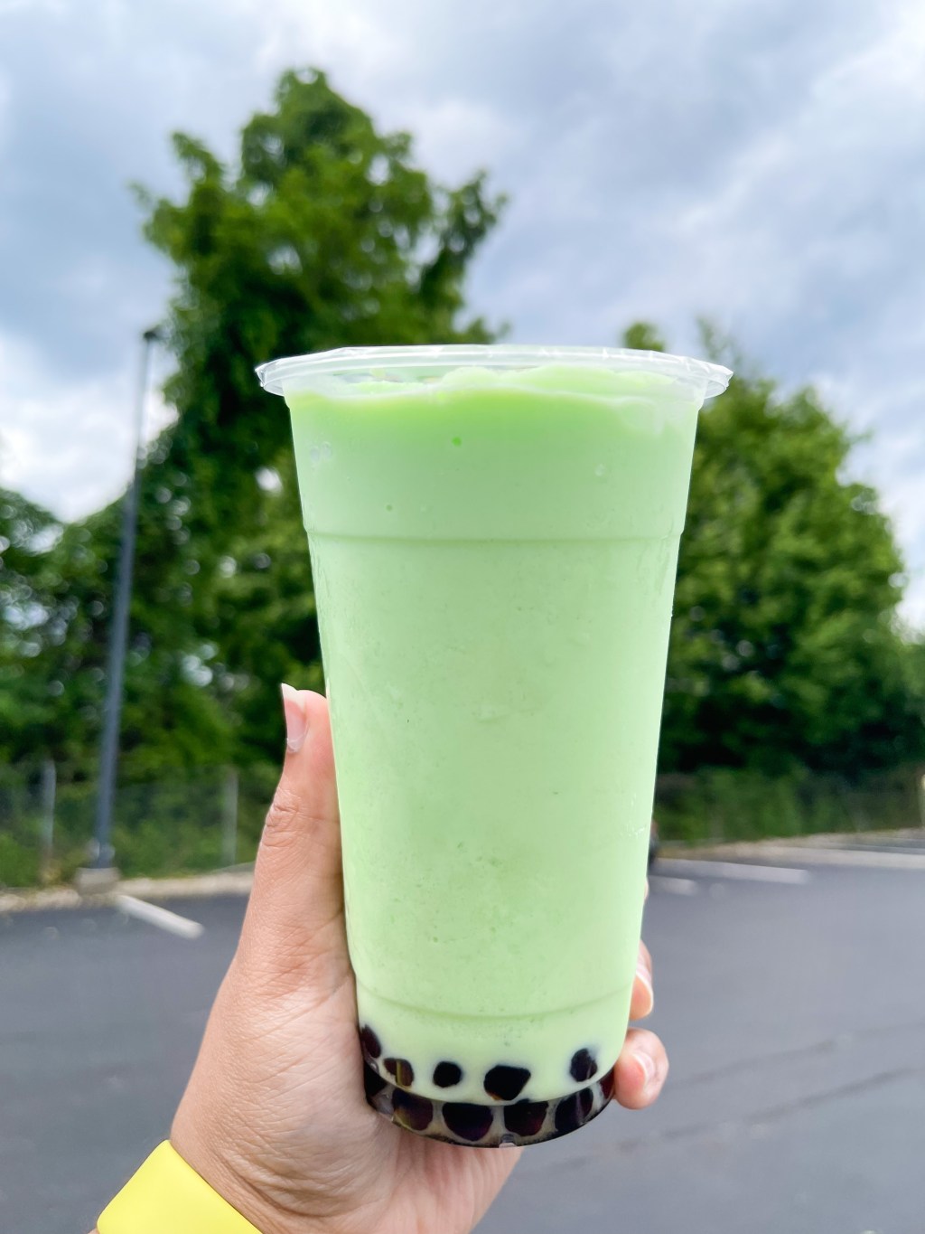 A hand holding a Honeydew Slush from Bubbles and Tea in Rockville, Maryland.