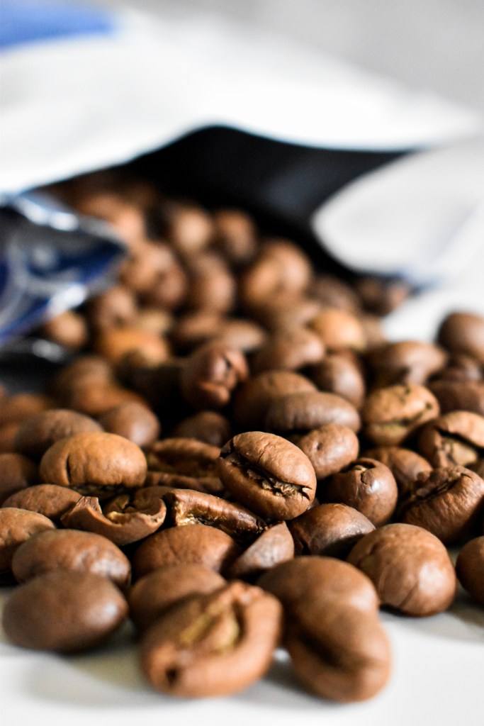 A close-up of a pile of Peaberry Robusta coffee beans from Nguyen Coffee Supply