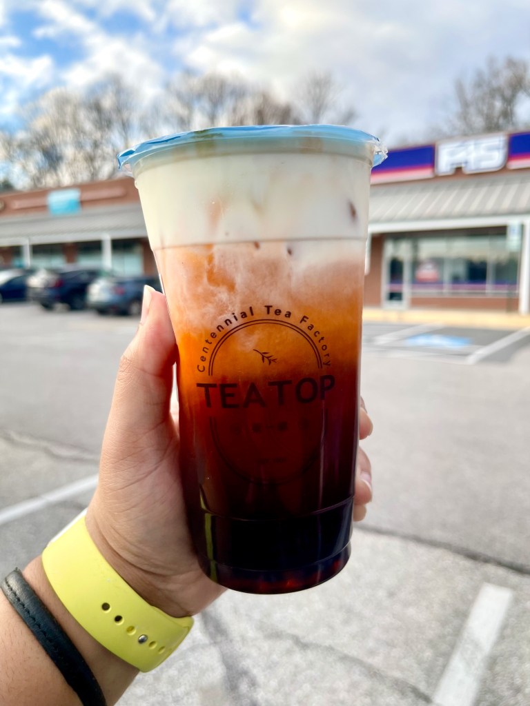 A hand holding a bubble tea drink
