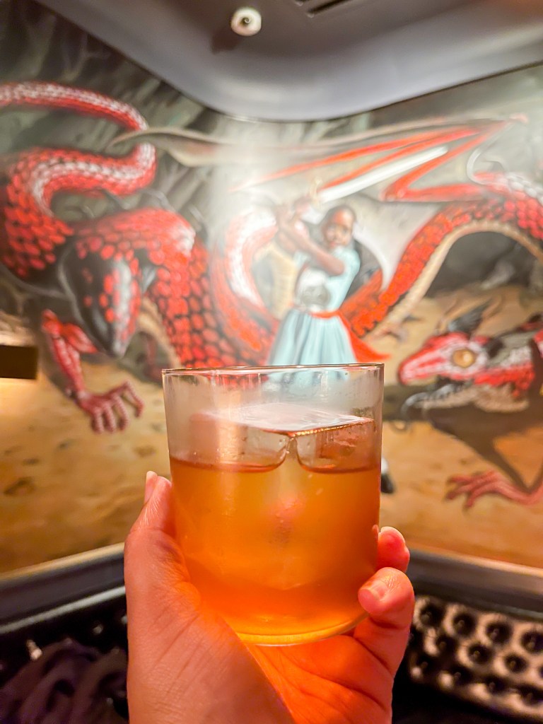 A hand holding a cocktail called Breakfast of Champions