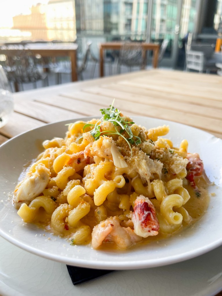 A plate of Seafood Mac and Cheese on a table. This dish is from Branch & Bird, a restaurant in Fort Worth, Texas.