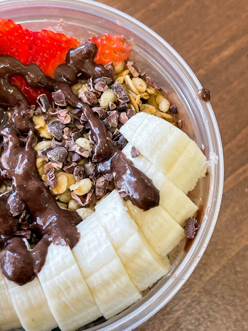 A smoothie bowl topped with granola, strawberries, and bananas