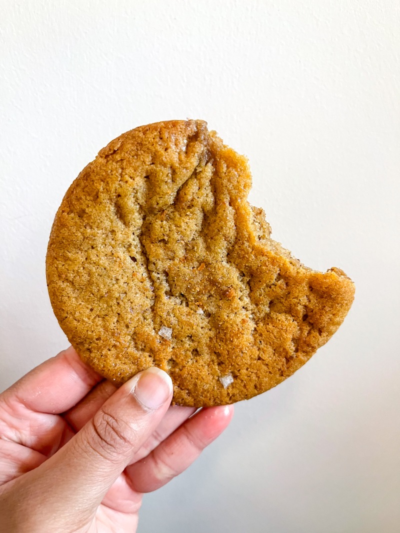 A hand holding a bitten cookie