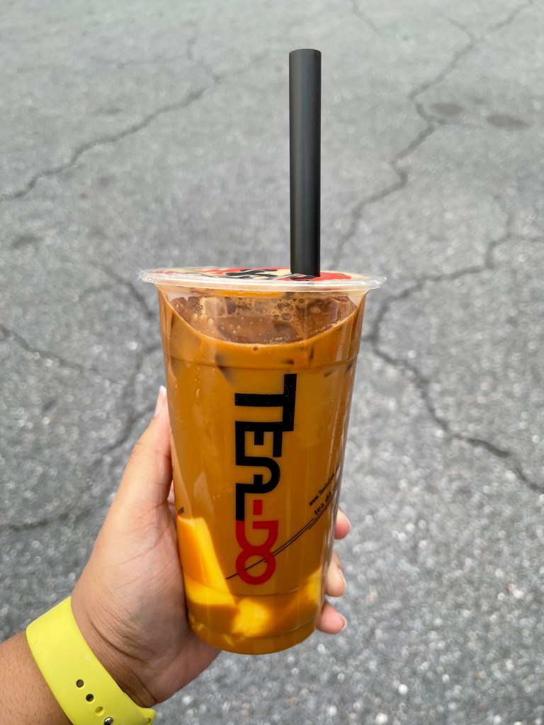 A hand holding a coffee drink