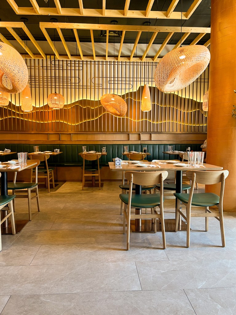 A room with tables, chairs, and light fixtures